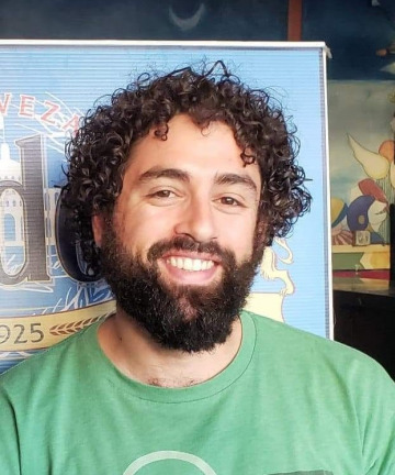 Man with curly hair smiling. 